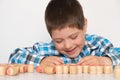 A preschool boy plays lotto, folds barrels with numbers on the table. The child learns to count