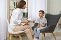 Preschool boy practicing sounds articulation during lesson with speech language therapist teacher.