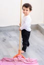 Preschool boy washes floors in balcony.