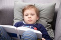 Preschool child carefully reads a book while lying at home Royalty Free Stock Photo