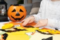 Preschool child creates Halloween origami paper bat crafts, close-up hands