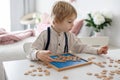 Preschool child, cute blond boy, playing with wooden numbers Royalty Free Stock Photo