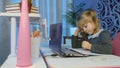 Bored kid listening audio lesson studying at table using digital laptop computer, doing homework Royalty Free Stock Photo