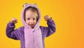 preschool child little shows strong strength tensing muscles in purple pajamas