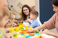 Preschool children sticking with plasticine in classroom