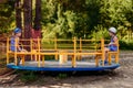 Preschool children in summer hats ride on the big carousel in the Park in the summer Royalty Free Stock Photo