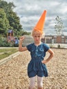 preschool funny Caucasian blonde girl with orange traffic cone sign on her head Royalty Free Stock Photo