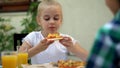 Preschool girl eating favorite italian pizza, enjoying tasty meal, food delivery