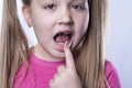 A preschool girl with her first adult incisors. The milk tooth has fallen out, and a permanent tooth grows in the open Royalty Free Stock Photo