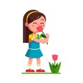 Girl kid holding tulip flower and smelling it Royalty Free Stock Photo