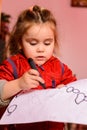 Preschool girl learns to draw a circle, black circles on a white sheet of paper, happy child Royalty Free Stock Photo