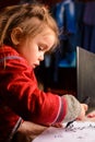 Preschool girl learns to draw a circle, black circles on a white sheet of paper, happy child Royalty Free Stock Photo