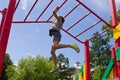 Preschool girl hanging walk along the monkey bars