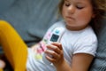 Preschool girl takes temperature and feeling sick. Toddler child with infrared in ear thermometer at home, high grade Royalty Free Stock Photo