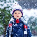 Preschool kid boy in colorful clothes playing outdoors during strong snowfall. Active leisure with children in winter on Royalty Free Stock Photo