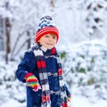 Preschool kid boy in colorful clothes playing outdoors during strong snowfall. Active leisure with children in winter on Royalty Free Stock Photo