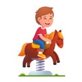 Preschool kid play riding rocking horse on spring Royalty Free Stock Photo