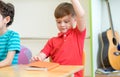 Preschool kid raise arm up to answer teacher question on whiteboard in classroom,Kindergarten education concept Royalty Free Stock Photo