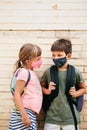 Preschool Kids with protective masks and backpacks talking Royalty Free Stock Photo