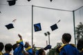 Preschool kids wearing graduated dress throwing cap and diplomat in sky in graduated celebration day.