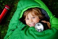 Preschool little girl in sleeping bag camping. Outdoors activity with children in summer. Fun and adventure camp, family and Royalty Free Stock Photo