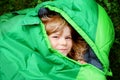 Preschool little girl in sleeping bag camping. Outdoors activity with children in summer. Fun and adventure camp, family and Royalty Free Stock Photo