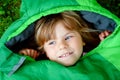 Preschool little girl in sleeping bag camping. Outdoors activity with children in summer. Fun and adventure camp, family Royalty Free Stock Photo