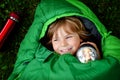 Preschool little girl in sleeping bag camping. Outdoors activity with children in summer. Fun and adventure camp, family Royalty Free Stock Photo