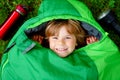 Preschool little girl in sleeping bag camping. Outdoors activity with children in summer. Fun and adventure camp, family Royalty Free Stock Photo