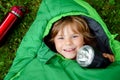 Preschool little girl in sleeping bag camping. Outdoors activity with children in summer. Fun and adventure camp, family Royalty Free Stock Photo