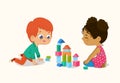 Preschool Red Hair Boy and African American Girl Kids playing with wooden bricks and blocks together in kindergarten