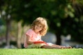 Preschool smiling pupil student boy writing to notebook in park on grass. Home children learning. Education childhood Royalty Free Stock Photo