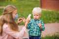 Preschool staff conducting children`s temperature outdoors every morning