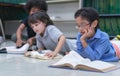 Preschool students laying on floor and rest the chin on the hand, read the book in library, Learning and education concept