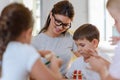 Preschool teacher with children playing with colorful wooden didactic toys at kindergarten Royalty Free Stock Photo