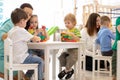 Preschool teacher with children playing with colorful wooden educational toys at kindergarten Royalty Free Stock Photo