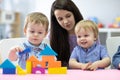 Preschool teacher and cute kids play in kindergarten Royalty Free Stock Photo