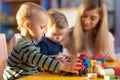 Preschool teacher and cute kids play in kindergarten Royalty Free Stock Photo