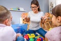 Preschool teacher talking to group of children sitting on a floor at kindergarten Royalty Free Stock Photo