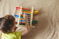 Preschooler baby learns to count. Cute child playing with abacus toy. Little boy having fun indoors at home, kindergarten or day c Royalty Free Stock Photo