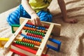 Preschooler baby learns to count. Cute child playing with abacus toy. Little boy having fun indoors at home Royalty Free Stock Photo