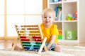 Preschooler baby learns to count. Cute child playing with abacus toy. Little boy having fun indoors at kindergarten Royalty Free Stock Photo