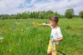 Preschooler boy blows big soap bubbles in a field on a bright sunny day Royalty Free Stock Photo