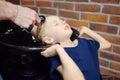 Preschooler boy getting haircut in barbershop. Children hairdresser washing hair for child. Cutting hair for kids Royalty Free Stock Photo