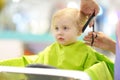 Preschooler boy getting haircut. Children hairdresser with professional tools - comb and scissors Royalty Free Stock Photo