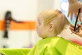 Preschooler boy getting haircut. Children hairdresser with professional tools - comb and scissors Royalty Free Stock Photo