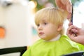 Preschooler boy getting haircut. Children hairdresser with professional tools - comb and scissors Royalty Free Stock Photo