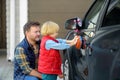 Preschooler boy helping his father washing family car. Little dad helper. Family with children spends time together Royalty Free Stock Photo