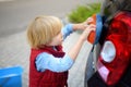 Preschooler boy helping his father washing family car. Little dad helper. Family with children spends time together Royalty Free Stock Photo