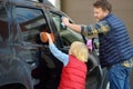 Preschooler boy helping his father washing family car. Little dad helper. Family with children spends time together Royalty Free Stock Photo